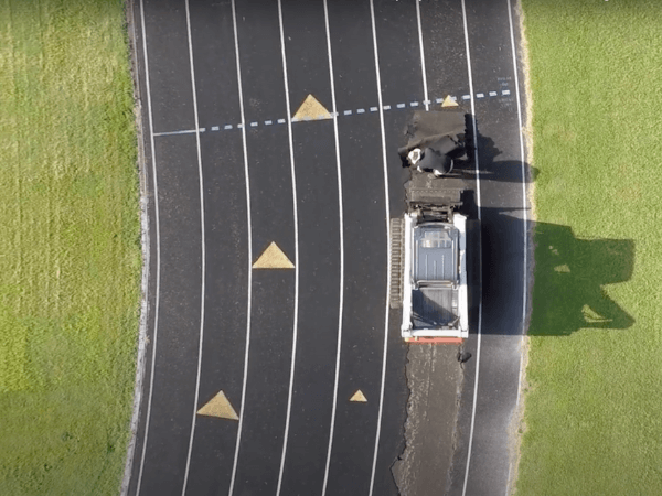 A truck is driving on a track in an aerial view.