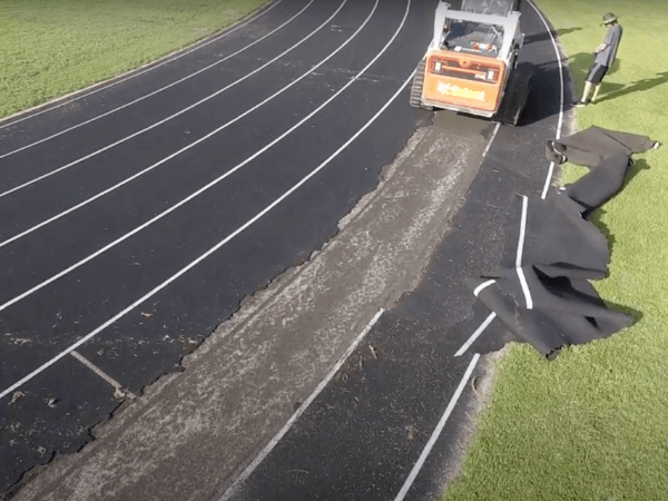 A man is working on a track with a bulldozer.
