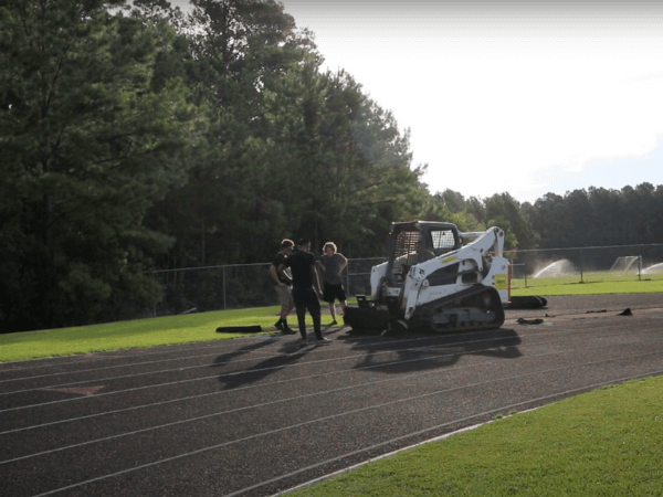A man is working on a track with a bulldozer.