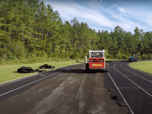 A construction worker is working on a track.