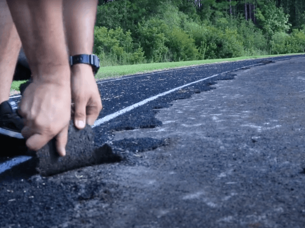 A person is putting asphalt on a road.